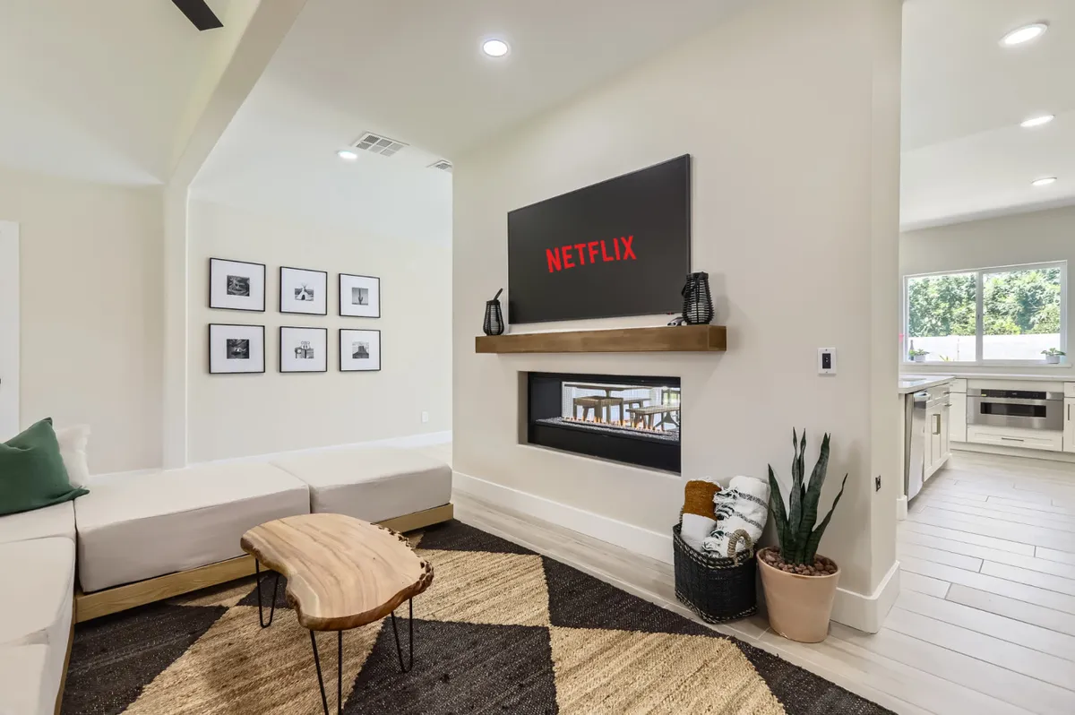 A comfortable living room with a Netflix screen, wooden coffee table, and contemporary decor. The space is designed for relaxation and entertainment, encouraging family movie nights or casual socializing after outdoor activities.